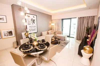 a living room with a table and chairs in a room at Modern 1BHK With World Class Amenities at Paramount Tower in Dubai