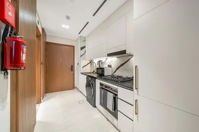 a kitchen with a stove and a washer and dryer at FIRST CLASS Studio Canal and Pool View in Dubai