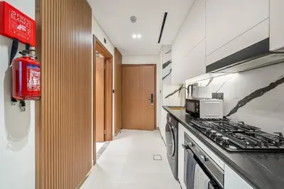 a kitchen with a stove top oven next to a hallway at FIRST CLASS Studio Canal and Pool View in Dubai