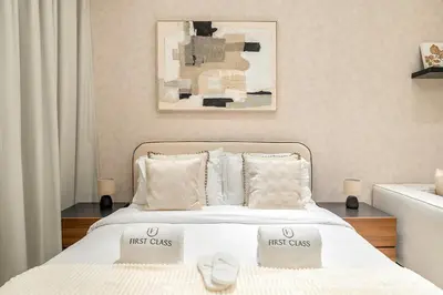 a white bed with two first class pillows on it at FIRST CLASS Studio Canal and Pool View in Dubai