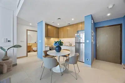 a kitchen with a table and chairs and a refrigerator at Luxury Seaview Apartment Near Bluewaters & JBR in Dubai