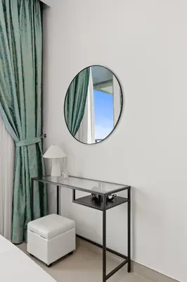 a dressing table with a mirror and a stool at Luxury Seaview Apartment Near Bluewaters & JBR in Dubai