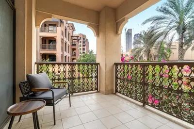a balcony with a chair and a table at FIRST CLASS 1BR Cozy Old Town Escape in Dubai