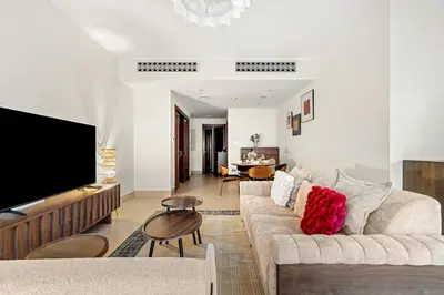 a living room with a couch and a flat screen tv at FIRST CLASS 1BR Cozy Old Town Escape in Dubai