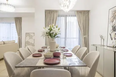 a dining room with a table and white chairs at Rimal 1 JBR Beach Access 3 BR in Dubai