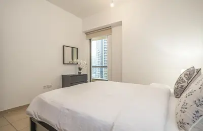 a white bedroom with a bed and a window at Rimal 1 JBR Beach Access 3 BR in Dubai