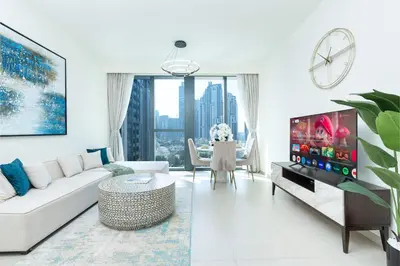 a living room with a white couch and a tv at PVH - Vibrant 1BR near Dubai Opera - BLVD Heights in Dubai