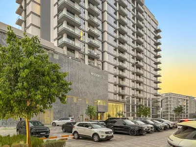a parking lot with cars parked in front of a large building at FIRST CLASS 1BR Cozy Luxe Escape in Dubai