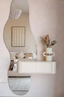 a mirror in a living room with a white couch at Serene 1BR Retreat with Pool & Gym by Safa Park in Dubai