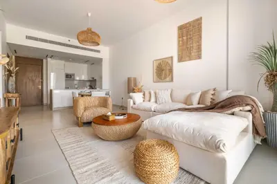 a living room with a couch and a table at Serene 1BR Retreat with Pool & Gym by Safa Park in Dubai