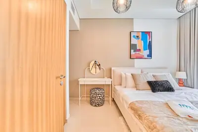 a bedroom with a large bed and a table at FAM Living - 2 Bedroom Aykon City Dubai in Dubai