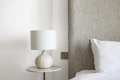 a white lamp sitting on a table next to a bed at Luxury Suite Huge Terrace Canal and Gevora Views with Infinity Pool in Dubai