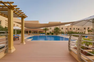 a swimming pool with a hammock over a wooden deck at Spacious 1BR Apartment Imperial Residence B JVT in Dubai