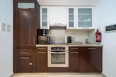 a kitchen with wooden cabinets and a stove top oven at Stylish Studio Retreat Heart of Downtown Dubai in Dubai
