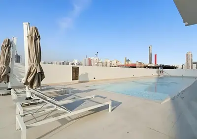 a swimming pool with two lounge chairs and a swimming poolvisorvisor at BLVD Luxe Stay with Pool Heart of JVC in Dubai