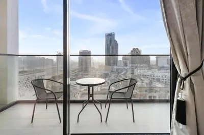 a table and chairs on a balcony with a view at BLVD Luxe Stay with Pool Heart of JVC in Dubai