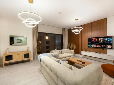 a living room with a couch and a tv at Luxurious 2BHK Sea & Dubai Eye View in Dubai