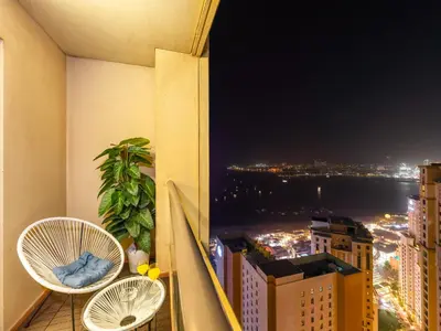 a balcony with two chairs and a view of the city at Luxurious 2BHK Sea & Dubai Eye View in Dubai