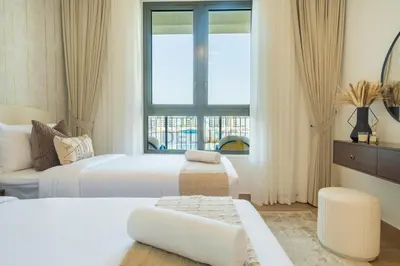 a bedroom with two beds and a window at Seafront 2BR, Within Walking Distance to La Mer Beach, Short Drive Away from Mercato Mall, La Sirene Building 2, La Mer by Deluxe Holiday Homes in Dubai