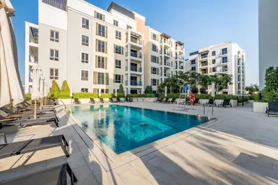 a swimming pool in front of a building at Seafront 2BR, Within Walking Distance to La Mer Beach, Short Drive Away from Mercato Mall, La Sirene Building 2, La Mer by Deluxe Holiday Homes in Dubai