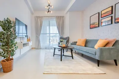 a living room with a couch and a table at Modern 1BR Retreat at Al Khail Heights, Al Quoz by Deluxe Holiday Homes in Dubai