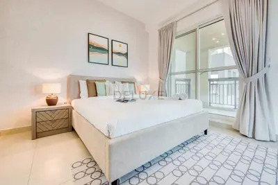 a bedroom with a bed and a large window at Modern 1BR Retreat at Al Khail Heights, Al Quoz by Deluxe Holiday Homes in Dubai