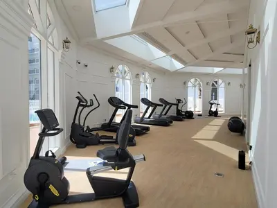 a gym with a row of treadmills and exercise bikes at Miracle Luxury Studio in Dubai
