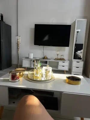 a living room with a table with a tv at Dubai heaven in Dubai