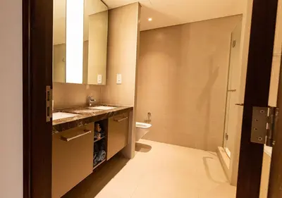 a bathroom with a sink and a toilet and a mirror at Luxury stay at Downtown Dubai-Walk to Burj Khalifa in Dubai