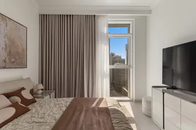 a hotel room with a bed and a large window at Stylish 2BR Beachfront Pool&Gym Access in Dubai