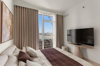 a bedroom with a large bed and a large window at Stylish 2BR Beachfront Pool&Gym Access in Dubai