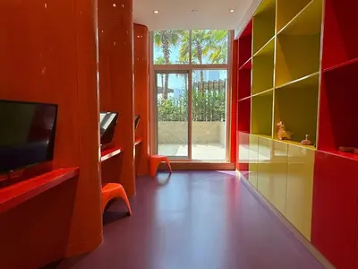 a living room with red and yellow walls and a television at Mahenti · Luxury Living at Its Finest in Dubai