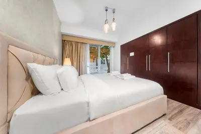 a bedroom with a large white bed and wooden cabinets at Prime Dubai Marina Spot - Beach, Dining and leisure in Dubai