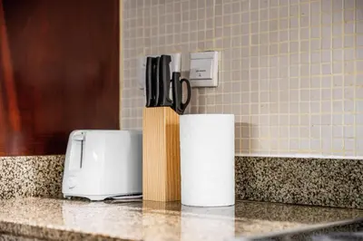 a counter with a knife block and a roll of paper towels at Prime Dubai Marina Spot - Beach, Dining and leisure in Dubai