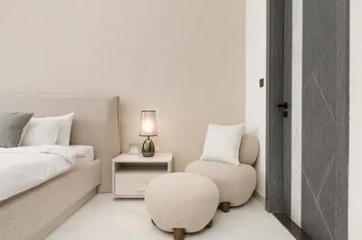 a bedroom with a bed and a chair and a table at Private Pool Stylish 1BR Arjan in Dubai