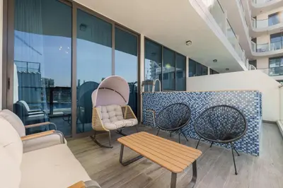 a balcony with chairs and a table on a building at Private Pool Stylish 1BR Arjan in Dubai