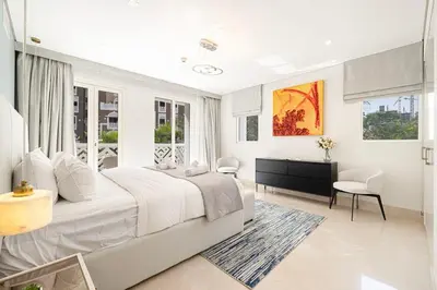 a white bedroom with a large bed and a desk at Villa with Private Pool in Palm Jumeirah in Dubai