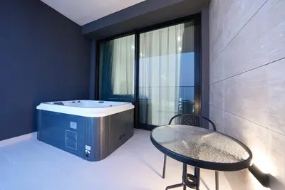 a bathroom with a tub and a table and a chair at Designer Studio Retreat with Jacuzzi & Canal Views in Dubai