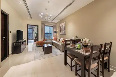 a living room with a table and a couch at Front Burj View - 6min to Dubai Mall - Pool - Gym in Dubai