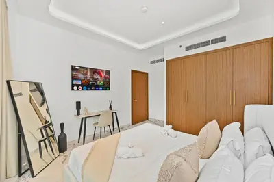 a living room with a white couch and a table at Riviera Azure Gateway Superior- 10min to Burj Khalifa, Dubai Mall and Airport and 20min to Marina in Dubai