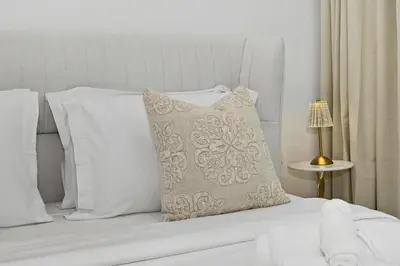 a white bed with a pillow on top of it at Riviera Azure Gateway Superior- 10min to Burj Khalifa, Dubai Mall and Airport and 20min to Marina in Dubai