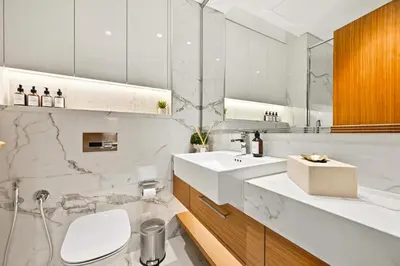 a white bathroom with a sink and a toilet at Riviera Azure Gateway Superior- 10min to Burj Khalifa, Dubai Mall and Airport and 20min to Marina in Dubai