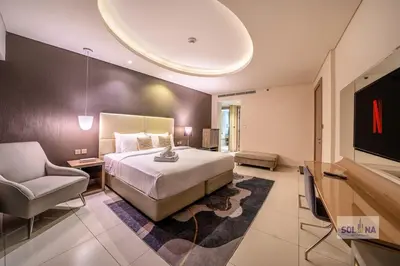 a hotel room with a bed and a television at Lux One Bedroom at Damac paramount in Dubai