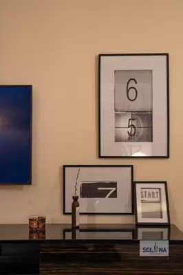 a living room with a table and pictures on the wall at Lux One Bedroom at Damac paramount in Dubai