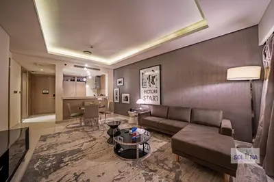 a living room with a couch and a table at Lux One Bedroom at Damac paramount in Dubai