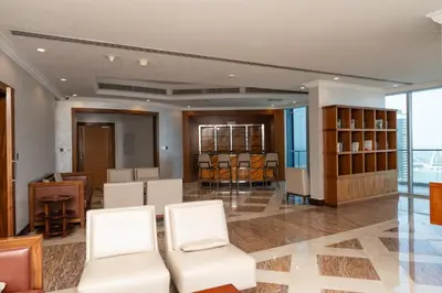 a lobby with white chairs and a table and some windows at BEACH FRONT I 2 Bedroom in TRIDENT JBR Dubai Marina I Palm & Sea Views I Amazing Balcony in Dubai