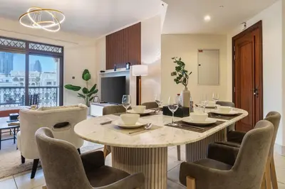 a dining room with a table and chairs and a television at Theatre Room - Pool Access - Central 2br Apartment in Dubai