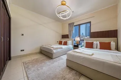 a bedroom with two beds and a large window at Theatre Room - Pool Access - Central 2br Apartment in Dubai