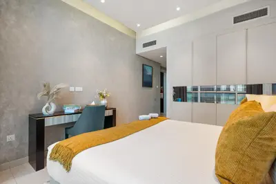 a bedroom with a white bed and a desk at Luxury 2 Bedroom Apartment DAMAC Uppercrest Downtown Near Dubai Mall in Dubai