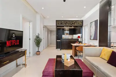 a living room with a couch and a tv and a table at Luxury 2 Bedroom Apartment DAMAC Uppercrest Downtown Near Dubai Mall in Dubai